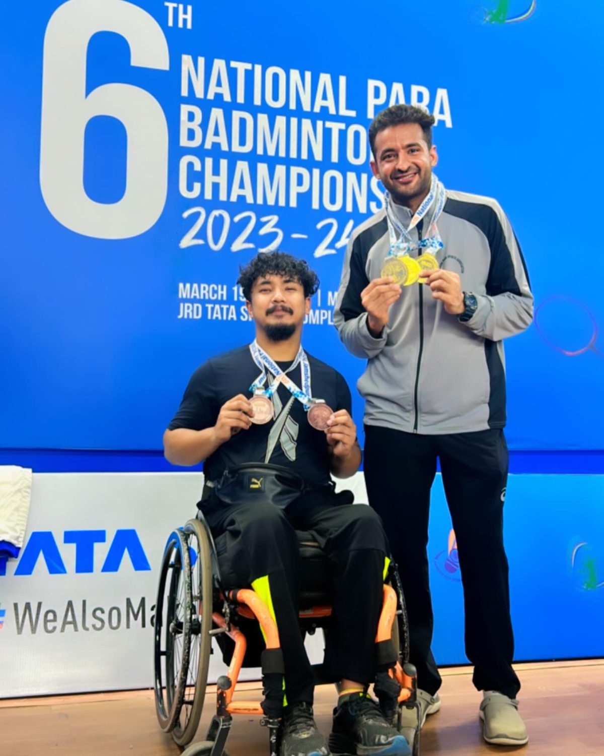Para-badminton player in a wheelchair holding a medal