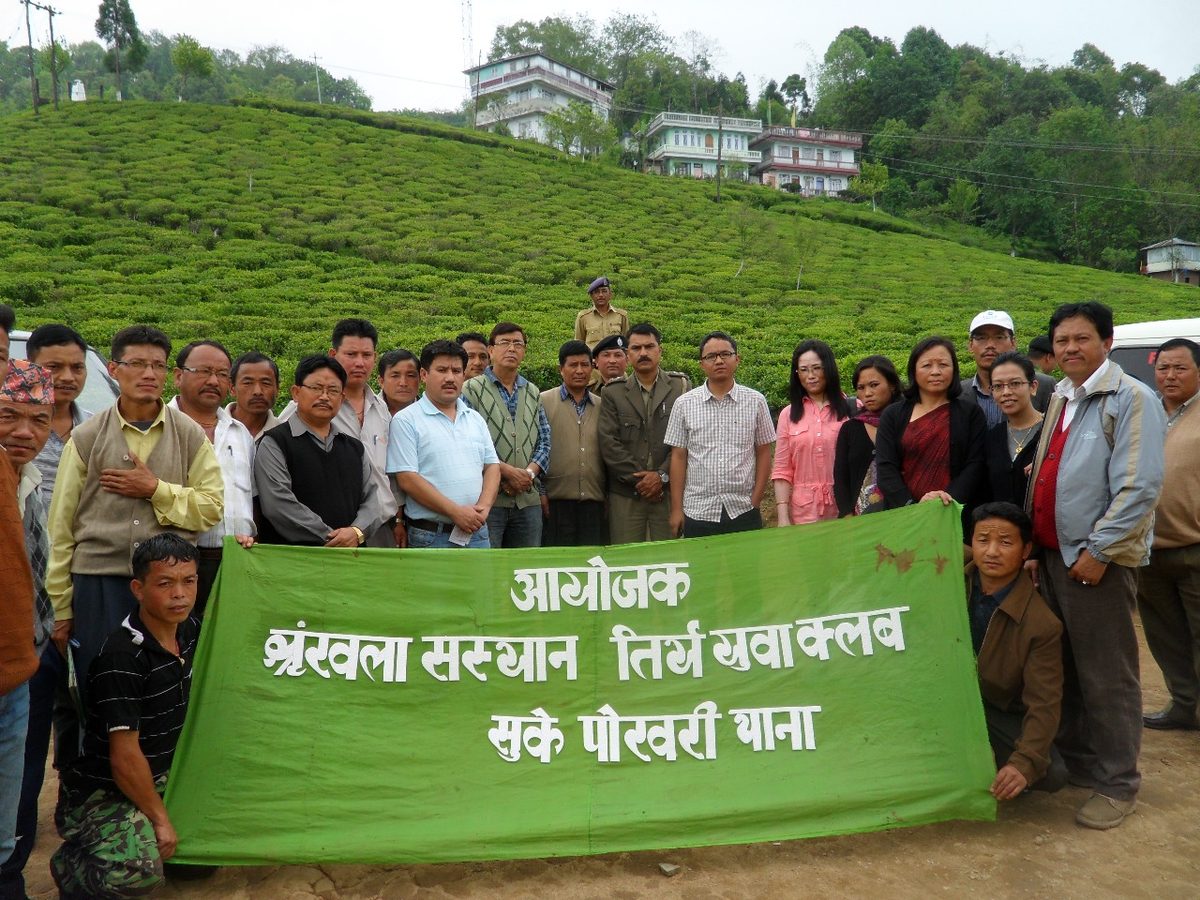 Community members with a banner in a tea garden